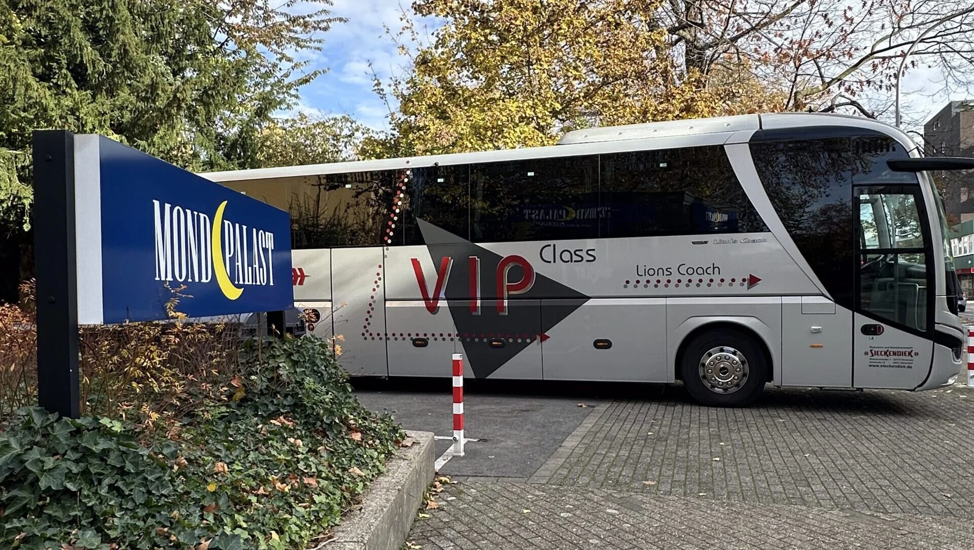Ein Reisebus vor dem Mondpalast und dem Theaterschild